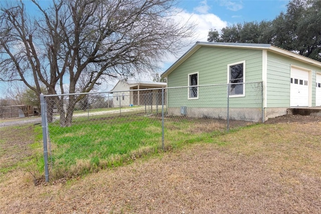 view of side of home featuring a garage and a lawn