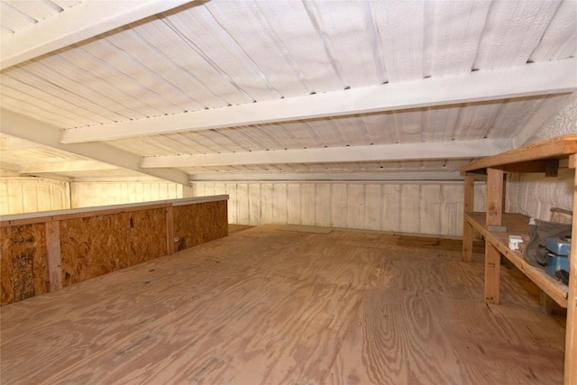 bonus room with lofted ceiling with beams, wood-type flooring, and wooden walls