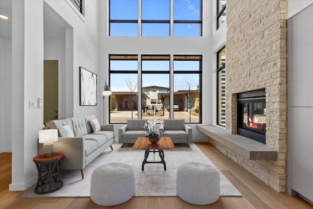 living room featuring a fireplace, wood finished floors, and baseboards