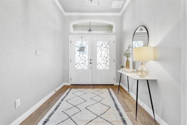 entryway with ornamental molding, hardwood / wood-style floors, and french doors