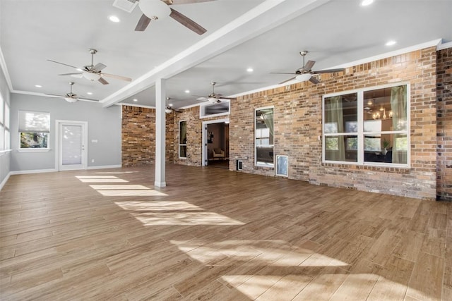 unfurnished living room featuring ornamental molding, light hardwood / wood-style floors, and brick wall