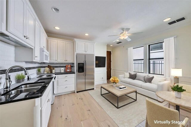 3701 Copper Ridge Ct, Austin, TX 78734 - kitchen with stainless steel fridge with ice dispenser, white microwave, light wood finished floors, white cabinetry, and recessed lighting