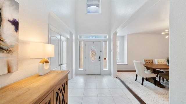 tiled foyer featuring a high ceiling