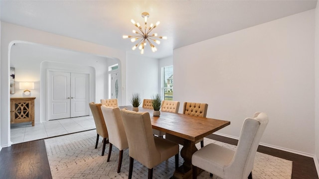 dining space with an inviting chandelier and light hardwood / wood-style flooring