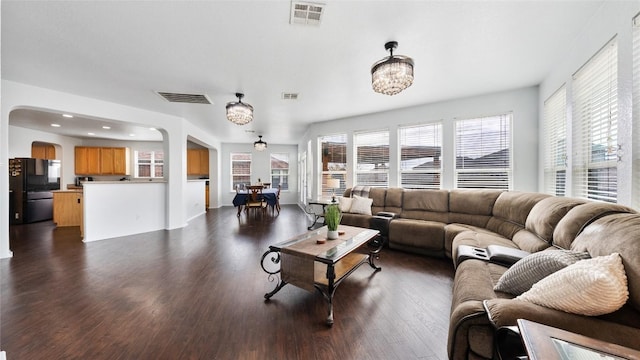 living room with a notable chandelier and dark hardwood / wood-style flooring