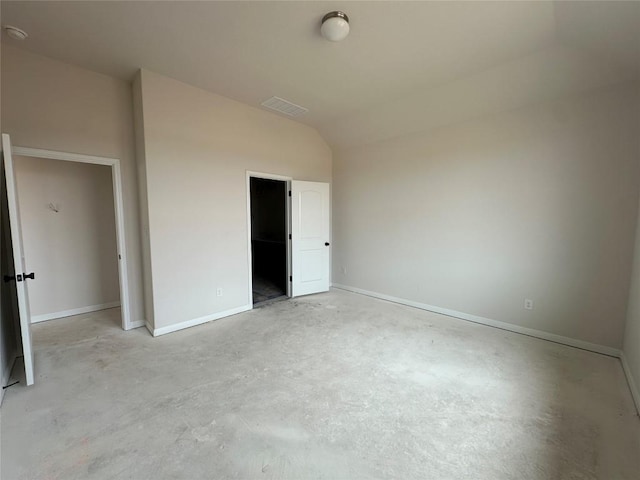 unfurnished bedroom featuring unfinished concrete flooring, visible vents, vaulted ceiling, and baseboards