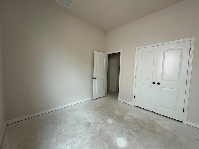 unfurnished bedroom featuring concrete floors, a closet, visible vents, and baseboards