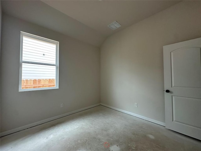 unfurnished room featuring lofted ceiling, concrete floors, visible vents, and baseboards