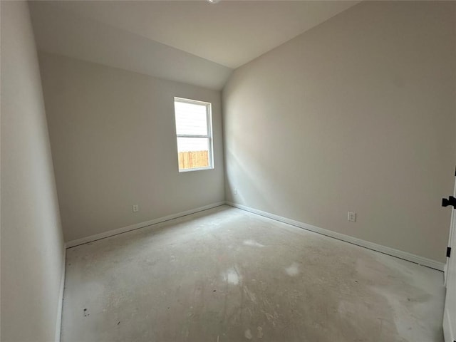 spare room featuring lofted ceiling