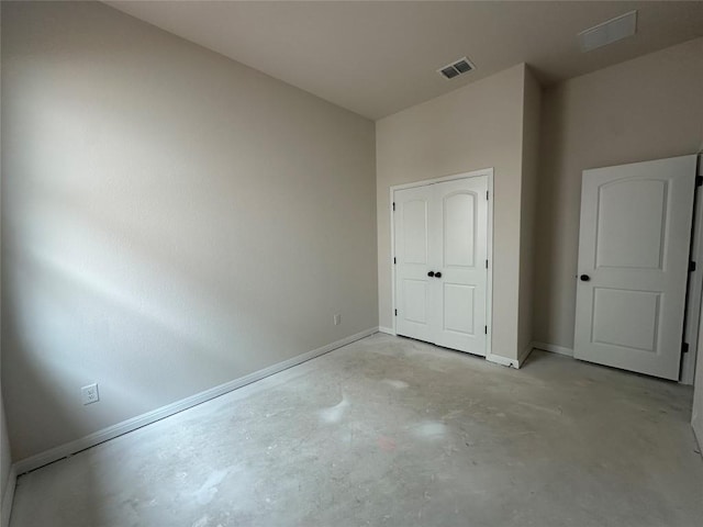 unfurnished bedroom with visible vents, concrete floors, and baseboards