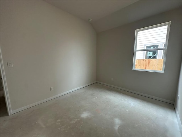 interior space with lofted ceiling, baseboards, and unfinished concrete floors