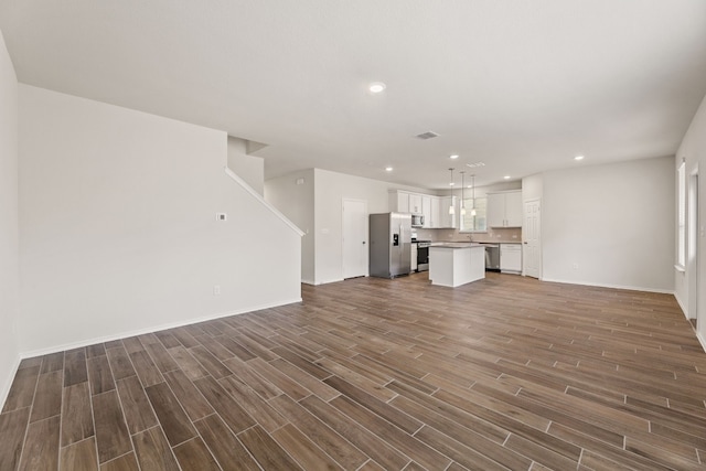 unfurnished living room with dark wood-type flooring