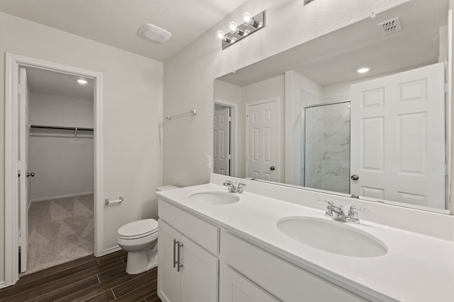 bathroom featuring vanity, toilet, and walk in shower