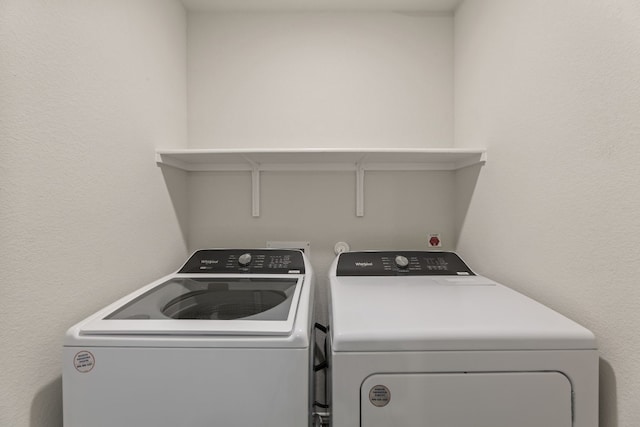 clothes washing area with washing machine and dryer