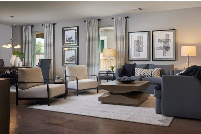 living room with an inviting chandelier and dark hardwood / wood-style flooring