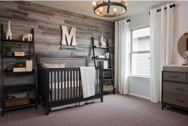 carpeted bedroom featuring multiple windows, a notable chandelier, and wood walls