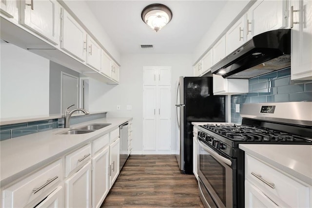 kitchen with sink, appliances with stainless steel finishes, dark hardwood / wood-style floors, white cabinets, and backsplash