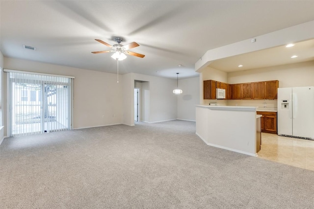 unfurnished living room featuring light carpet and ceiling fan