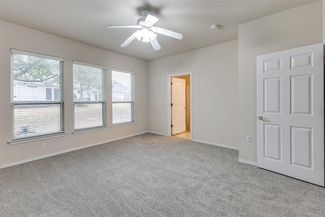 spare room featuring light carpet and ceiling fan