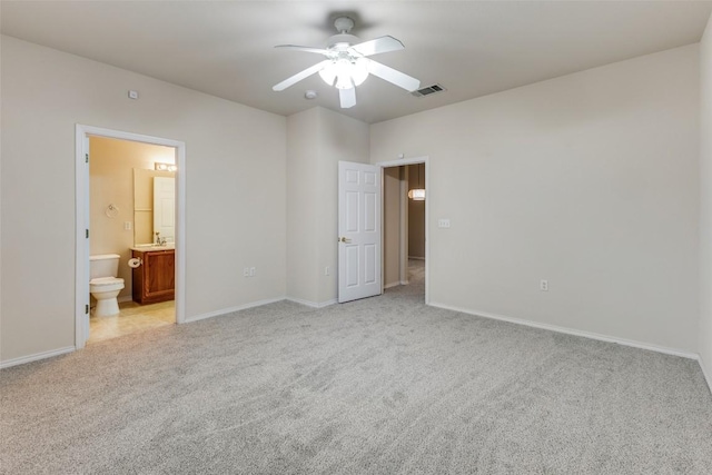 unfurnished bedroom featuring ceiling fan, ensuite bathroom, sink, and light carpet