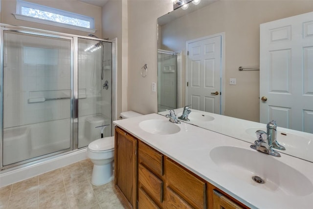 bathroom featuring tile patterned flooring, vanity, toilet, and walk in shower