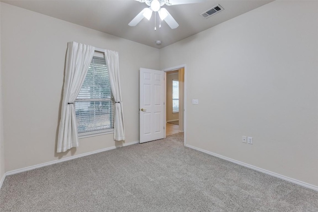 empty room featuring light colored carpet and ceiling fan