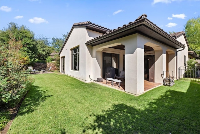 rear view of house featuring a patio and a yard