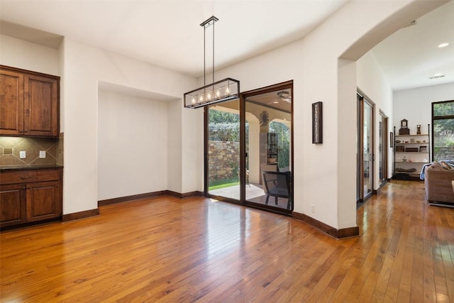 unfurnished dining area featuring wood-type flooring and plenty of natural light