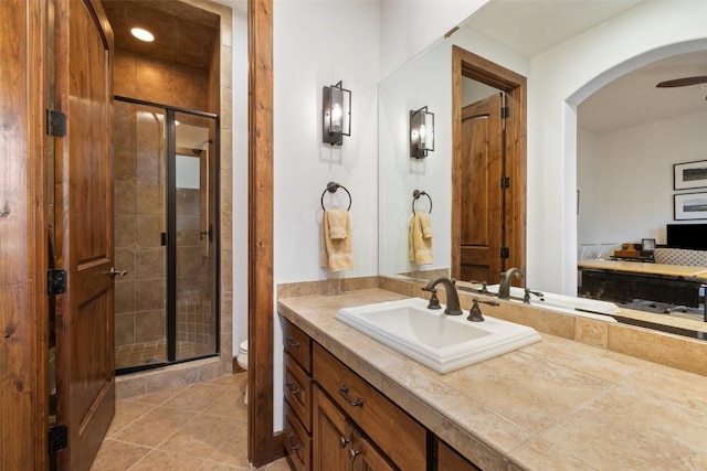 bathroom with tile patterned floors, vanity, toilet, and a shower with shower door