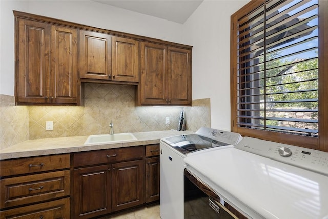 laundry area with sink, washer and clothes dryer, and cabinets