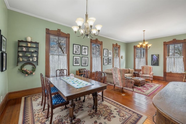 dining room featuring crown molding, hardwood / wood-style flooring, and a chandelier