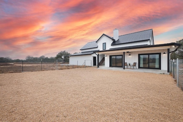 back house at dusk with a patio