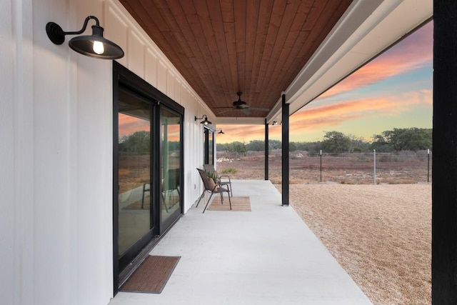 patio terrace at dusk featuring ceiling fan