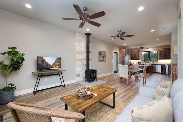 living room featuring a wood stove and light wood-type flooring