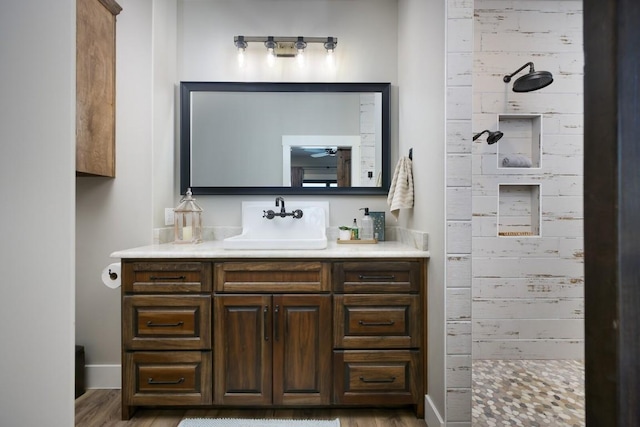 bathroom featuring vanity, wood-type flooring, and a shower