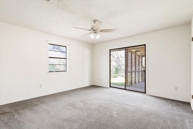 carpeted spare room with ceiling fan and a textured ceiling