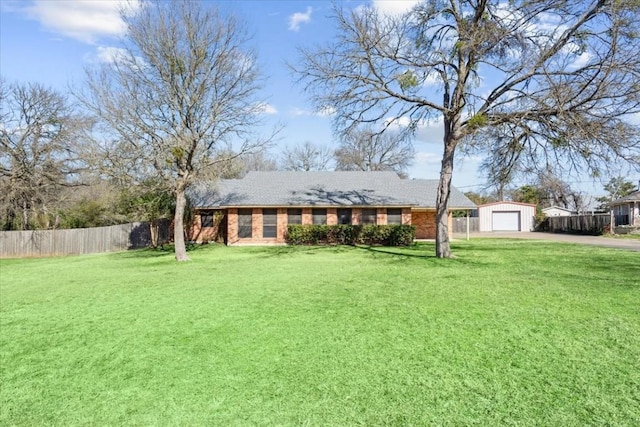 single story home featuring a garage, an outbuilding, and a front lawn