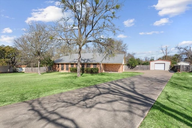 view of front facade featuring a garage, an outbuilding, and a front lawn