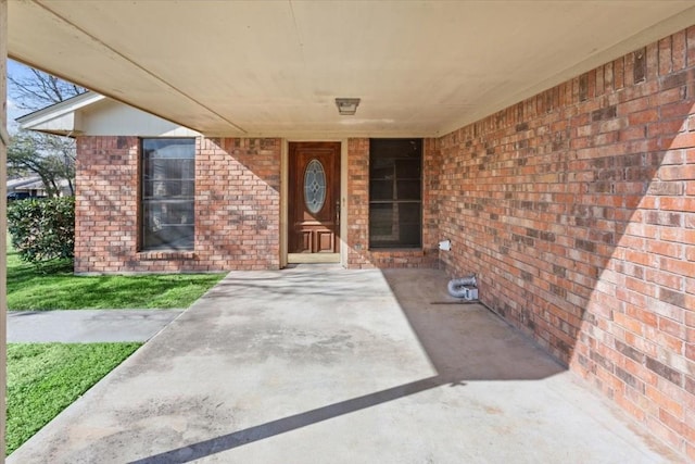 view of exterior entry with a patio