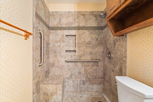 bathroom with toilet and a tile shower