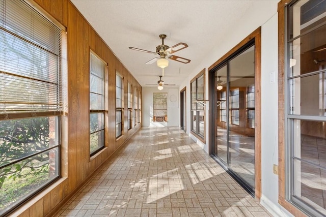 corridor featuring a wealth of natural light and wooden walls