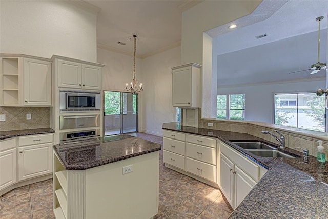 kitchen featuring white cabinetry, sink, ornamental molding, kitchen peninsula, and stainless steel appliances