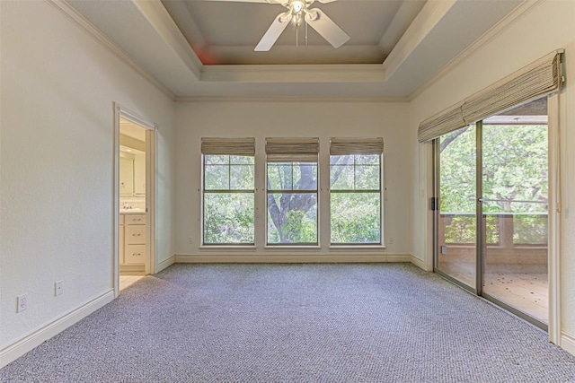 unfurnished sunroom featuring ceiling fan, a raised ceiling, and a wealth of natural light