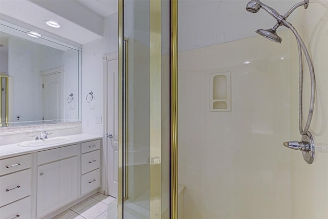 bathroom with an enclosed shower, vanity, and tile patterned flooring