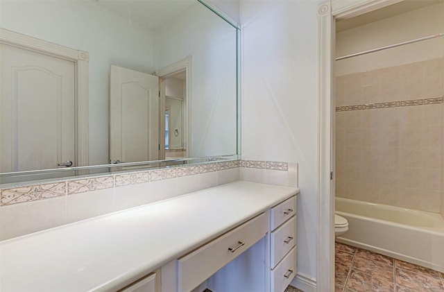 full bathroom with vanity, toilet, tiled shower / bath combo, and backsplash