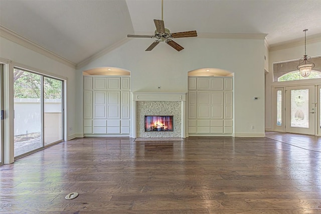 unfurnished living room with crown molding, high vaulted ceiling, dark hardwood / wood-style flooring, a tile fireplace, and ceiling fan