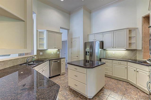 kitchen featuring dark stone countertops, ornamental molding, stainless steel appliances, and white cabinets