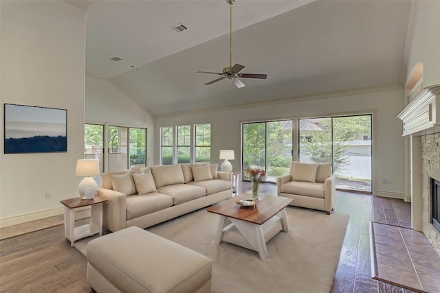 living room with ceiling fan, high vaulted ceiling, a fireplace, and light hardwood / wood-style flooring