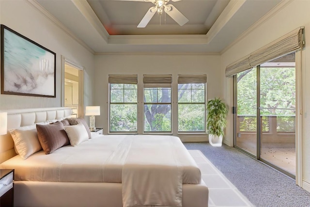 carpeted bedroom with multiple windows, crown molding, access to exterior, and a tray ceiling