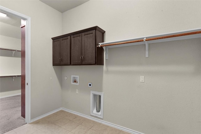 laundry room featuring gas dryer hookup, light tile patterned floors, electric dryer hookup, hookup for a washing machine, and cabinets